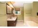Clean bathroom with double sinks, a bathtub, and tile flooring at 1 Westbury Pl, Durham, NC 27707