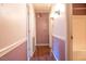 Long hallway with mauve walls and wood flooring at 1 Westbury Pl, Durham, NC 27707