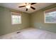 Bedroom with two windows, ceiling fan, and neutral walls at 1 Westbury Pl, Durham, NC 27707