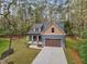 An aerial view of a gray two-story home with a brown and tan roof, red door, attached garage, and covered entryway at 1431 Alabama Ave, Sanford, NC 27332