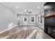 Living room with wood-look flooring, a fireplace with a dark wood mantel, and large windows at 1431 Alabama Ave, Sanford, NC 27332