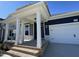 Covered front porch with white columns and brick steps leading to the front door at 441 Edison Rail Ln, Knightdale, NC 27545