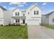 Two-story white house with gray door, brick steps, and a two-car garage at 6525 Winter Spring Dr, Wake Forest, NC 27587