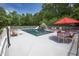 Relaxing pool area with patio furniture and red umbrella at 1153 Four Wheel Dr, Wake Forest, NC 27587