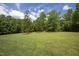 Spacious backyard with lush green grass and mature trees at 1153 Four Wheel Dr, Wake Forest, NC 27587