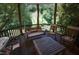 Rustic wooden deck with a swing and rocking chairs, overlooking the backyard at 1153 Four Wheel Dr, Wake Forest, NC 27587