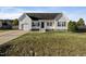 Simple white house with a dark door, attached garage, and a small front porch at 96 Abram Ct, Broadway, NC 27505