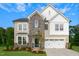 Two story home with stone and siding accents, two car garage, and landscaping at 94 Macy Cir, Wendell, NC 27591