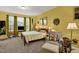 Cozy bedroom with wood bed frame, sitting area, and large windows at 1203 Lotus Lilly Dr, Durham, NC 27713