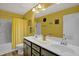 Bathroom with double vanity, shower, and yellow walls at 1203 Lotus Lilly Dr, Durham, NC 27713