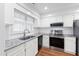 Modern kitchen featuring white cabinets, granite countertops, and stainless steel appliances at 1321 Dylan Heath Ct, Raleigh, NC 27608