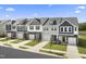 Aerial view of charming townhouses with gray and blue siding, white garage doors, and manicured lawns at 45 Lavender Ln # 173, Clayton, NC 27520