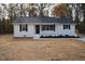 White brick ranch house with black shutters, small front porch, and landscaped yard at 352 Faucette Mill Rd, Hillsborough, NC 27278