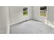 Well-lit bedroom with grey carpet and two windows at 615 Wildaro Ct, Hillsborough, NC 27278
