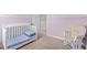 Bedroom with crib, rocker, and light purple walls at 918 E Green St # A102, Franklinton, NC 27525