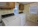 Bright laundry room with washer, dryer, and cabinets at 124 Jack Bennett Rd, Chapel Hill, NC 27517
