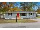 Newly renovated gray house with red door and small yard at 509 Keith St, Knightdale, NC 27545