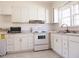 White kitchen with new appliances and tile flooring at 823 E Holly St, Rocky Mount, NC 27801