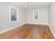 Well-lit bedroom with hardwood floors and two windows at 4505 Laymans Chapel Rd, Durham, NC 27704