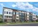 New townhome community with three-story homes, featuring brick and siding exteriors and balconies at 1508 Village Hall Ln, Wake Forest, NC 27587