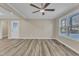 Living room with large window, wood-look floors, and ceiling fan at 1518 Parks Village Rd, Zebulon, NC 27597