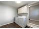 Bright laundry room with washer, dryer, and upper cabinets at 309 E Millbrook Road Rd, Raleigh, NC 27609