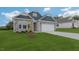 Two-story house with stone and blue siding, two car garage, and green lawn at 1680 Abberly Pl, Graham, NC 27253