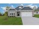 Attractive two-story home with stone and blue siding, a two-car garage, and a well-manicured lawn at 1680 Abberly Pl, Graham, NC 27253