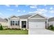 One-story home with gray siding, white garage door, and landscaping at 2508 Trevana Way, Graham, NC 27253