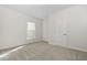 Bright bedroom with carpet flooring, a window, and a door leading to another room at 302 Sailfish Ct, Durham, NC 27703