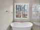 Relaxing bathroom with free-standing tub and large window overlooking backyard at 2637 Trifle Ln, Wake Forest, NC 27587