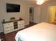 Main bedroom with dresser, king-size bed, and hardwood floors at 3214 Tump Wilkins Rd, Stem, NC 27581