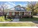 Brick home with a large front porch, solar panels, and well-maintained lawn at 401 E 2Nd St, Kenly, NC 27542