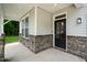 Covered front porch with stone pillars and a dark-colored front door at 8740 Maxine St # 7 Selma, Willow Springs, NC 27592