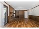 Living room with brick fireplace, wood paneling, and hardwood flooring at 1204 Breedlove Rd, Nashville, NC 27856