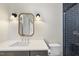 Modern bathroom with dark vanity, white sink, and frameless shower at 154 Leatherwood Ln, Chapel Hill, NC 27517