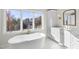 Spa-like bathroom with a free-standing tub, modern vanity, and natural light at 154 Leatherwood Ln, Chapel Hill, NC 27517