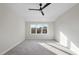 Spacious bedroom with gray carpet, ceiling fan, and large window at 154 Leatherwood Ln, Chapel Hill, NC 27517