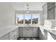 Bright laundry room with white quartz countertops and gray cabinets at 154 Leatherwood Ln, Chapel Hill, NC 27517