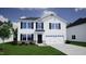 Two-story house with white siding, black trim, stone accents, and a two-car garage at 30 Calabria Ct, Franklinton, NC 27525