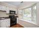 White kitchen cabinets with black appliances at 3116 Coachmans Way, Durham, NC 27705