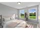 Bedroom with large windows, view of green space, and stylish decor at 8749 Maxine St # 11 Holly, Willow Springs, NC 27592