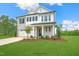 Two-story home with gray brick and white accents, two-car garage, and landscaped yard at 8749 Maxine St # 11 Holly, Willow Springs, NC 27592