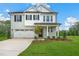 Two-story home with gray brick and white accents, two-car garage, and landscaped yard at 8749 Maxine St # 11 Holly, Willow Springs, NC 27592
