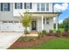 Front entrance with a covered porch, gray brick exterior, and landscaping at 8749 Maxine St # 11 Holly, Willow Springs, NC 27592