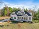 Two-story house with gray stone and white siding, front porch, and landscaping at 1360 Cedar Grove Rd, Pittsboro, NC 27312