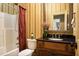 Bathroom with shower/tub combo, dark vanity, and striped wallpaper at 318 Rawls Church Rd, Angier, NC 27501