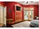 Main bedroom with a circular bed, red walls, and French doors opening to a pool at 318 Rawls Church Rd, Angier, NC 27501