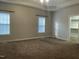 Main bedroom with carpet, neutral walls, and multiple windows at 15 Madinah Ct, Youngsville, NC 27596