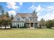 Two-story home with gray siding, stone accents, and a covered porch at 200 Holbrook Hill Ln, Holly Springs, NC 27540